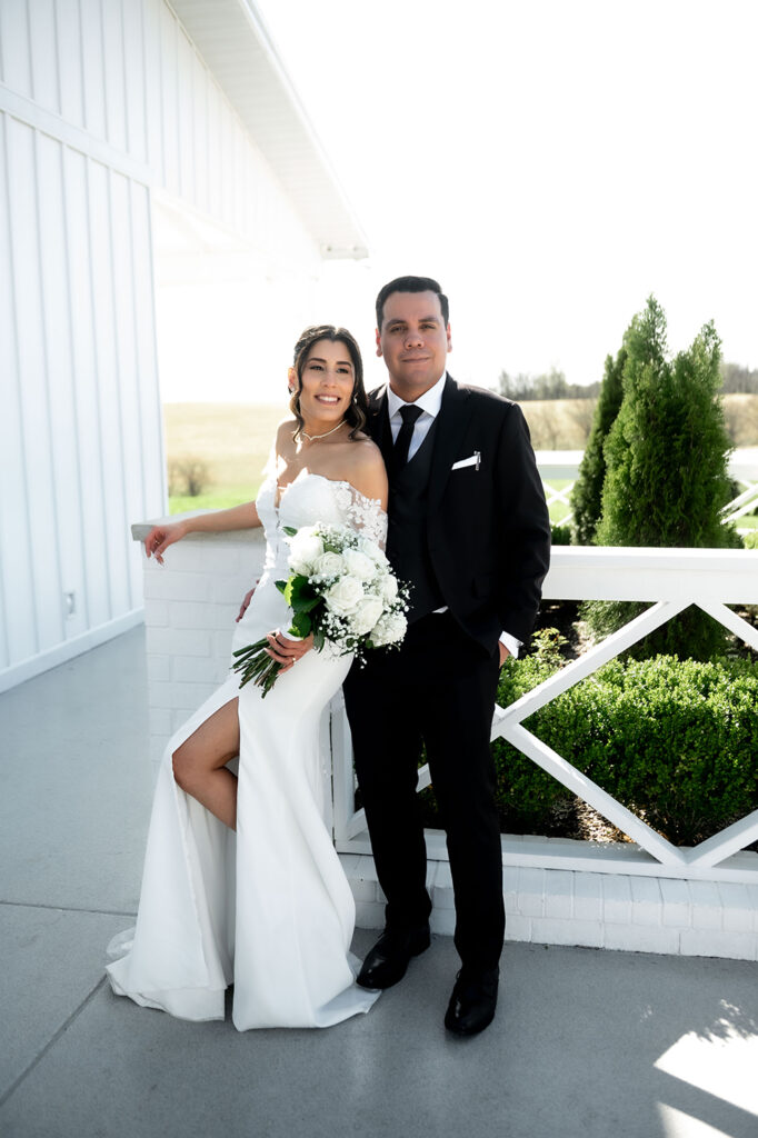 Couple holding hands near a wooden fence