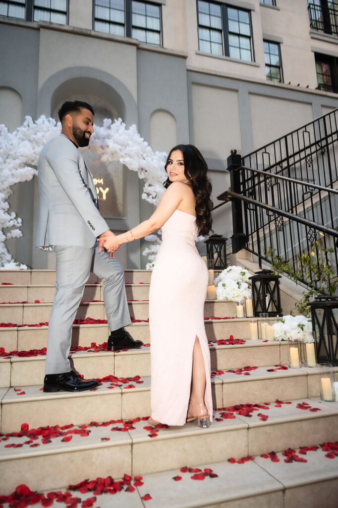 Groom proposing on one knee at the base of the staircase in Franklin hotel