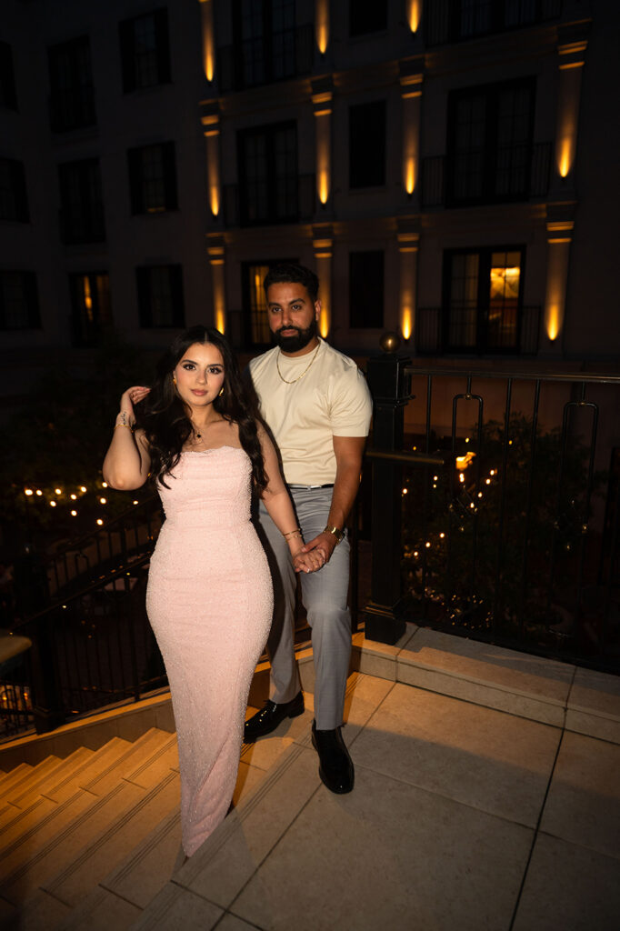 Emotional moment between couple framed by romantic lighting and floral arch